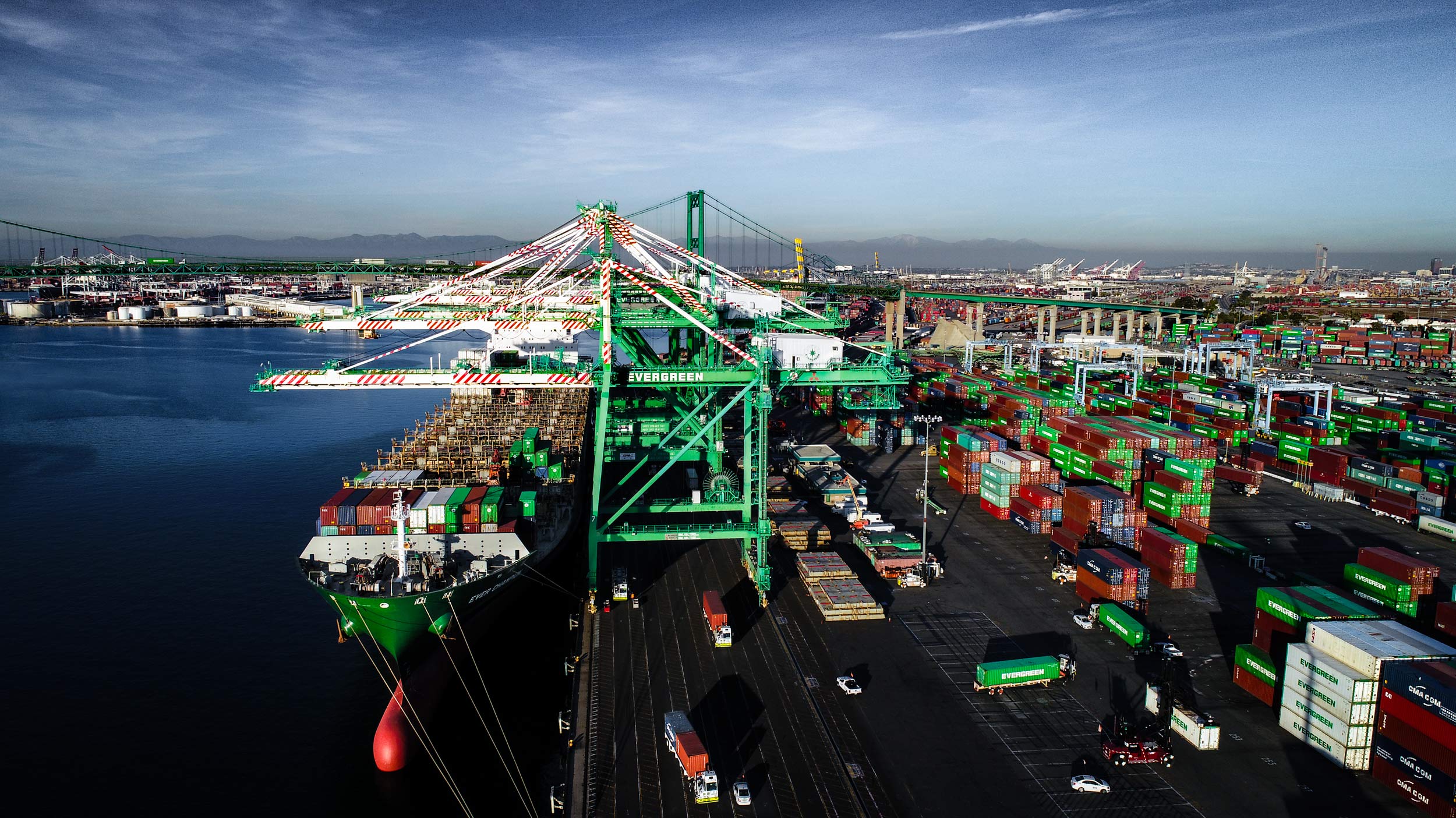 Aerial view of Evergreen crane unloading shipping containers from a ship onto semi trucks in the Port of Long Beach | Scott Gable industrial photographer 