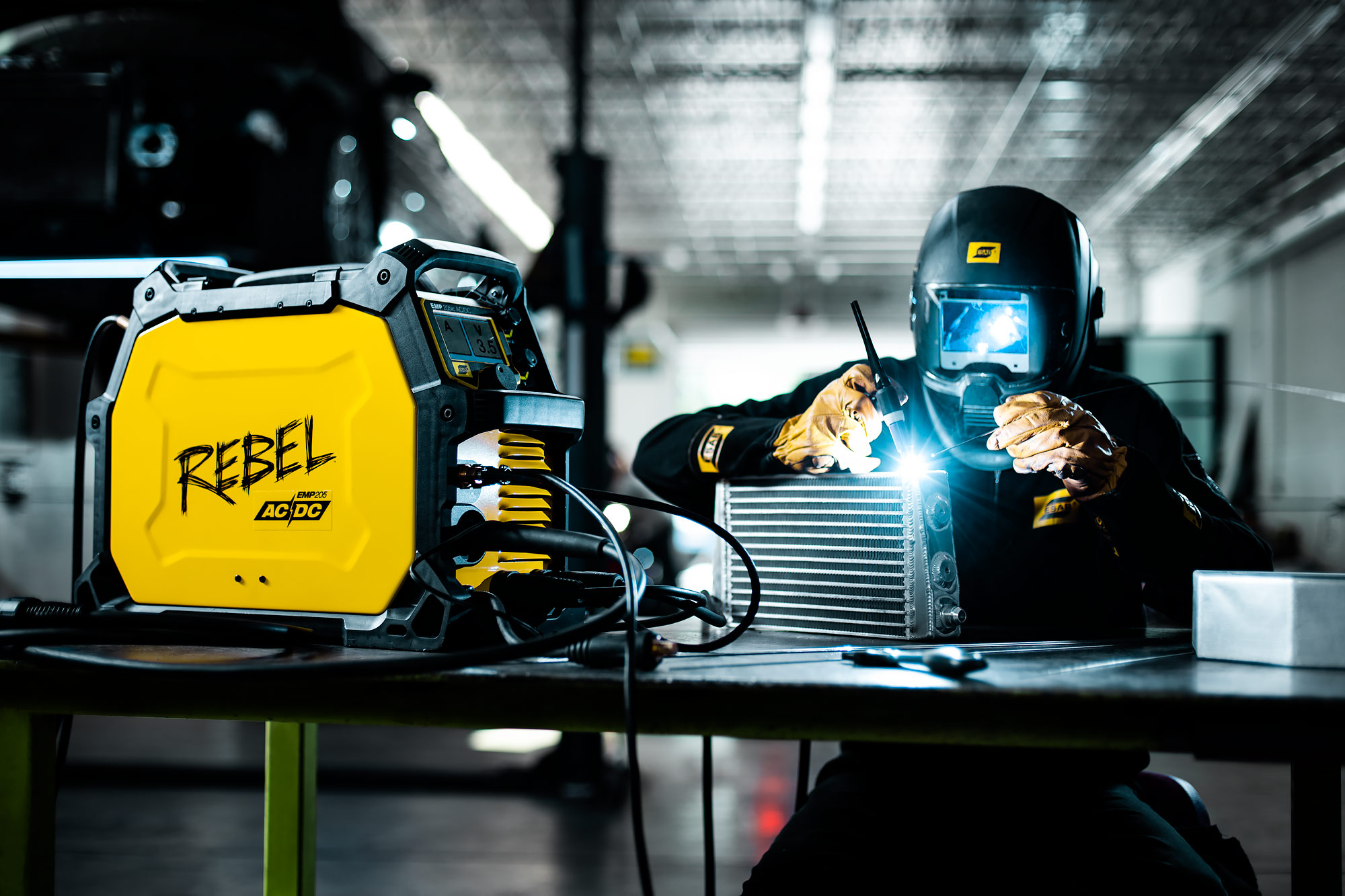 Welder works sitting at bench |  Scott Gable industrial photographer