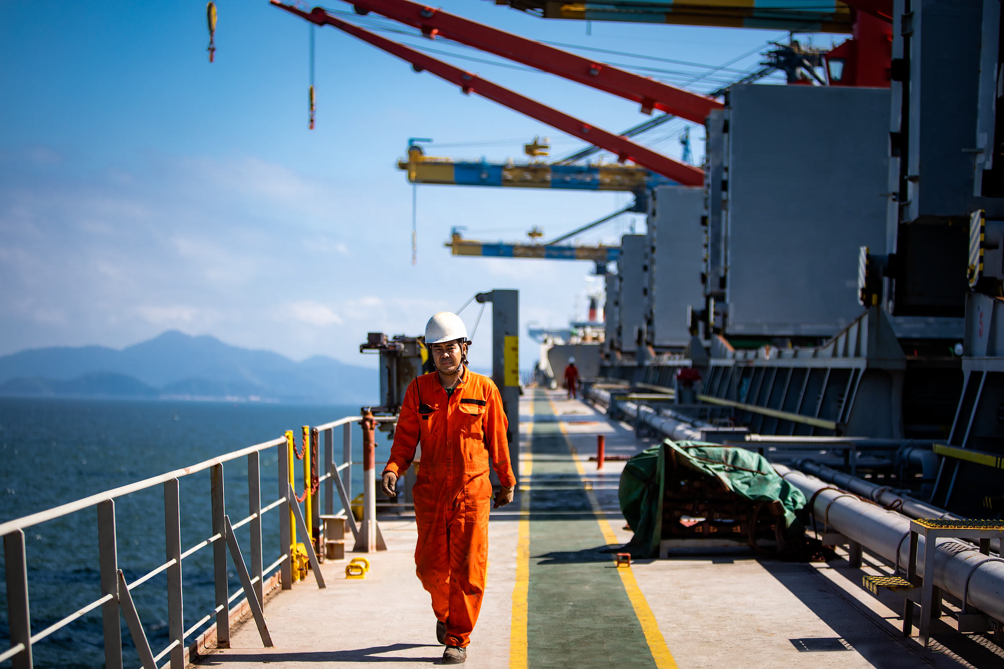 Dockworker walking beneath industrial cargo cranes |  Scott Gable industrial photographer