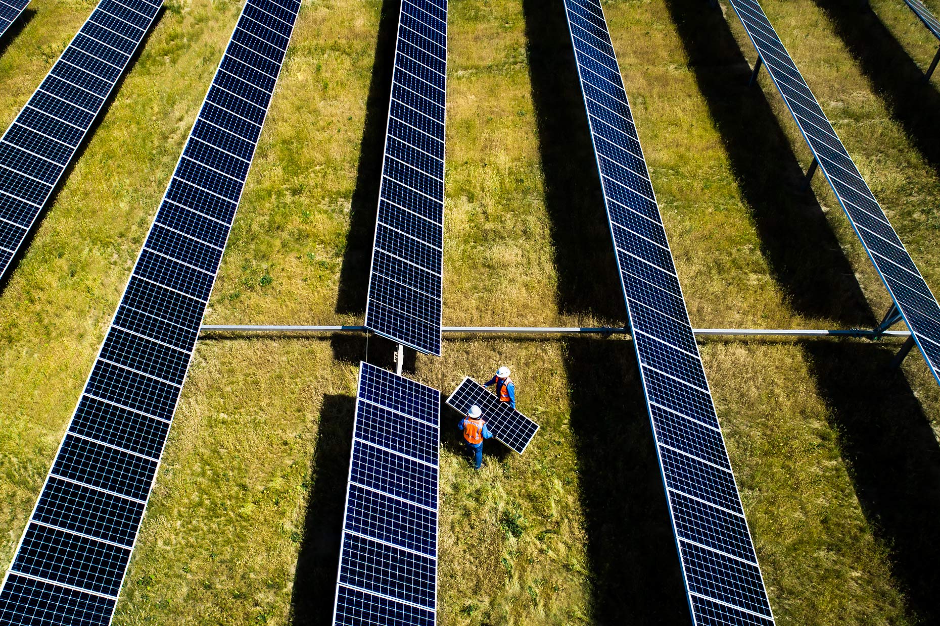 Drone view as two technicians replace a panel in a solar array | Scott Gable industrial photographer