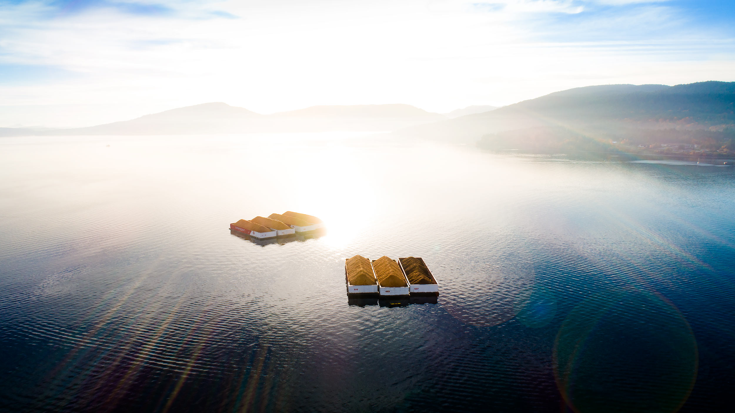 Aerial view of timber barges on shimmering water | Scott Gable industrial photographer
