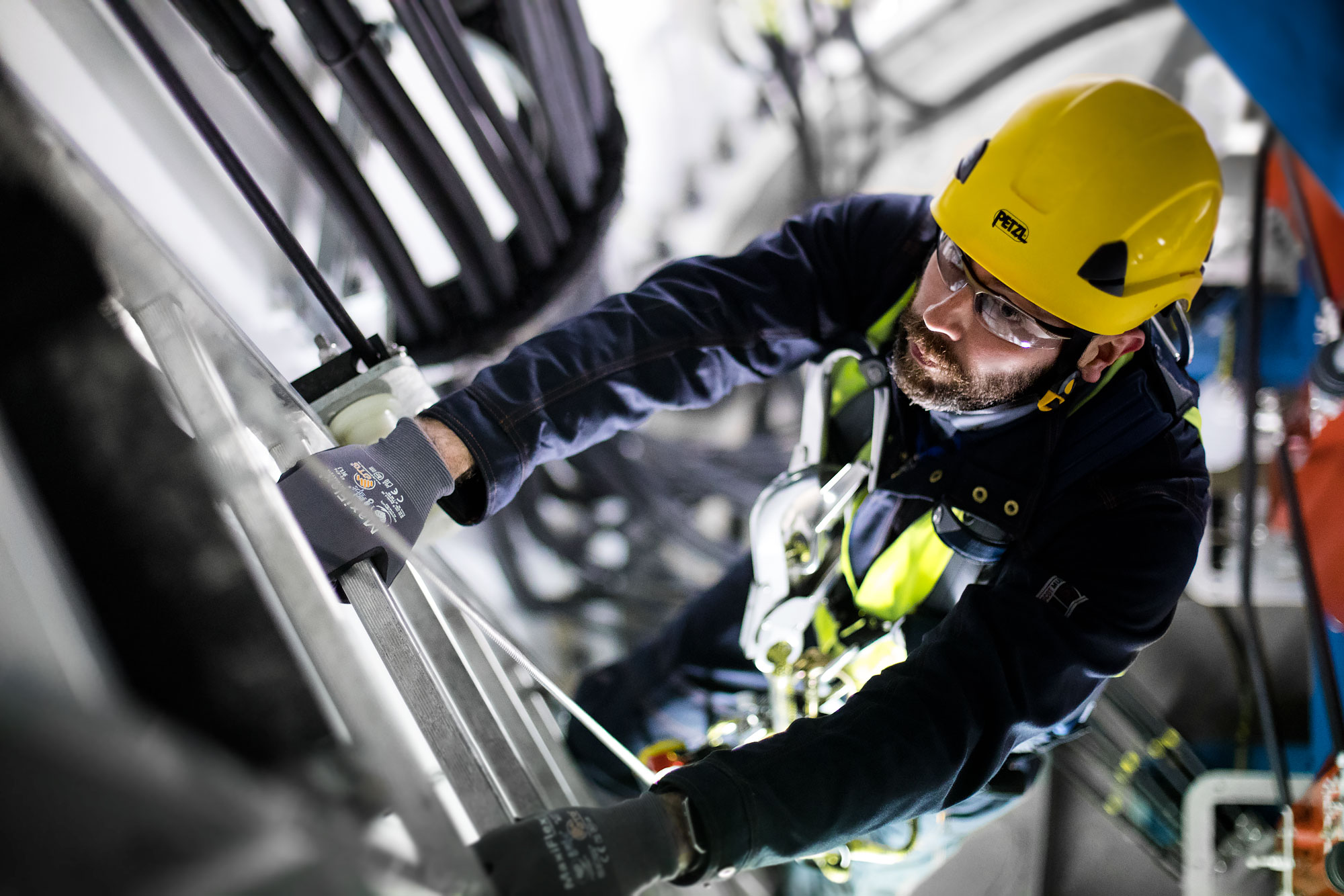Technician climbs access ladder inside of a wind turbine |  Scott Gable industrial photographer