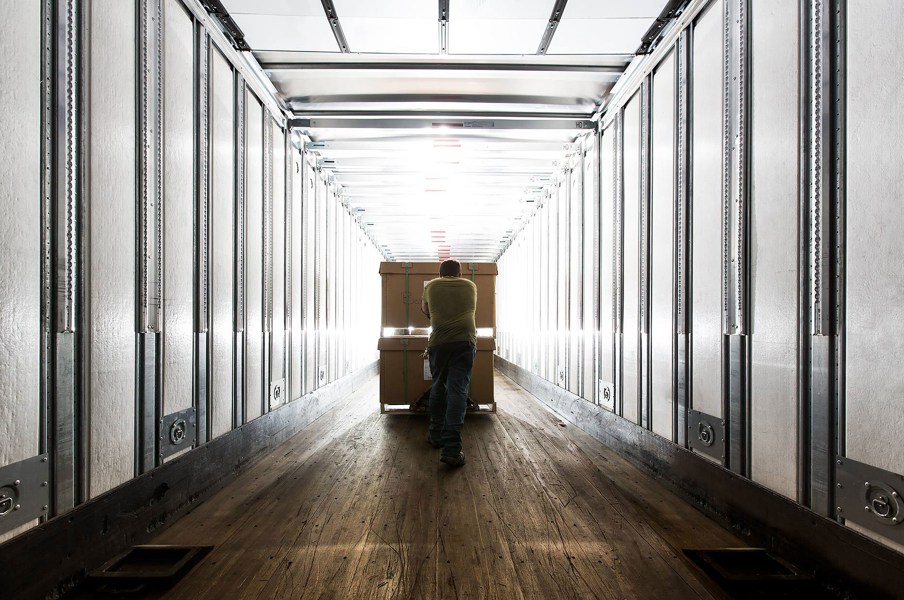 Warehouse worker pushes a load of boxes down a hallway |  Scott Gable industrial photographer