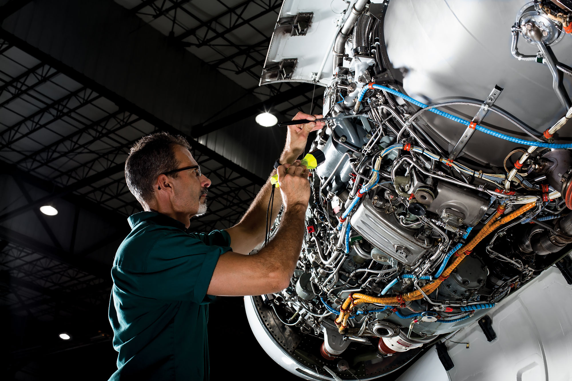 technician inspects jet engine cowling
